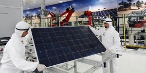 Two Qatar Solar Energy technicians handle a solar panel